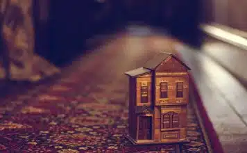 brown wooden house miniature on red carpet