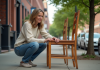 Femme inspectant une chaise en bois vintage dans la rue