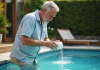 Homme en été versant un floculant naturel dans une piscine
