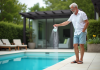 Effet bicarbonate de soude : optimiser l’équilibre piscine naturellement Homme d'âge moyen versant du bicarbonate dans une piscine extérieure